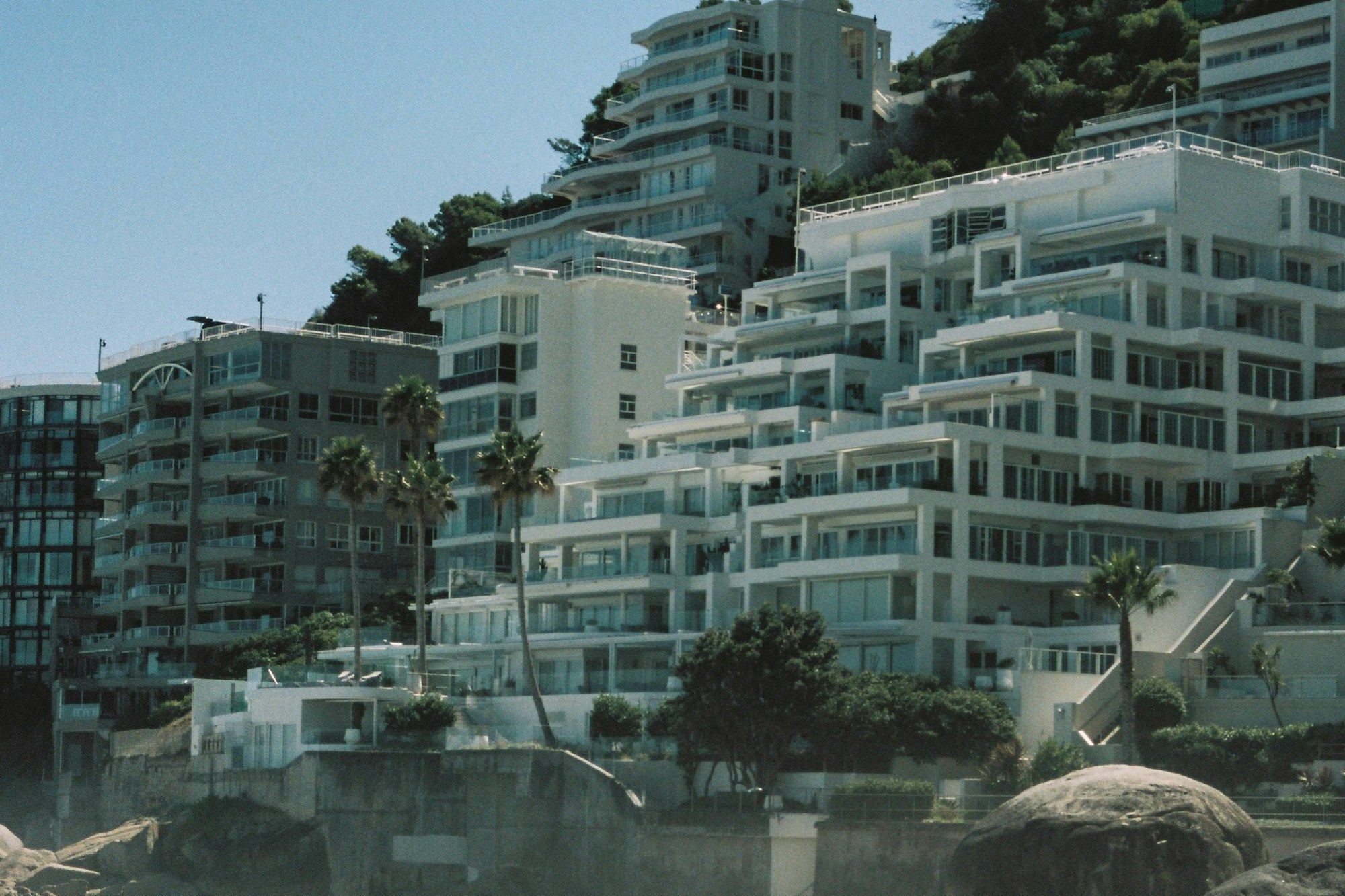 Modern white homes above a boulder beach on Cape Town's Atlantic seaboard
