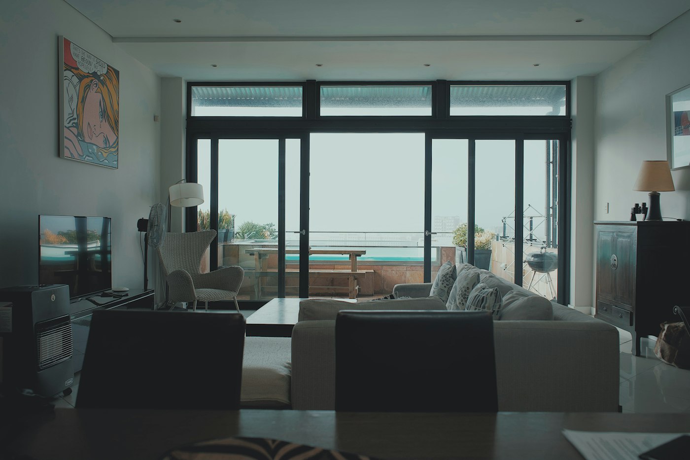 A modern lounge with floor-to-ceiling windows looking out to the ocean